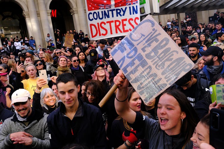 Protesters without masks waving placards