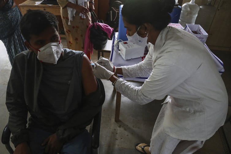 Young Indian man being vaccinated.