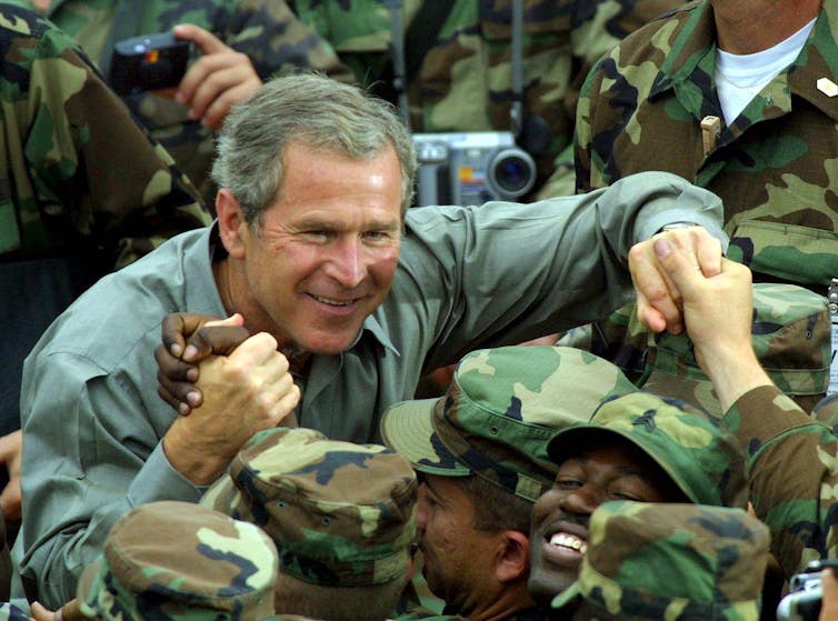 George W Bush shaking hands with US troops/