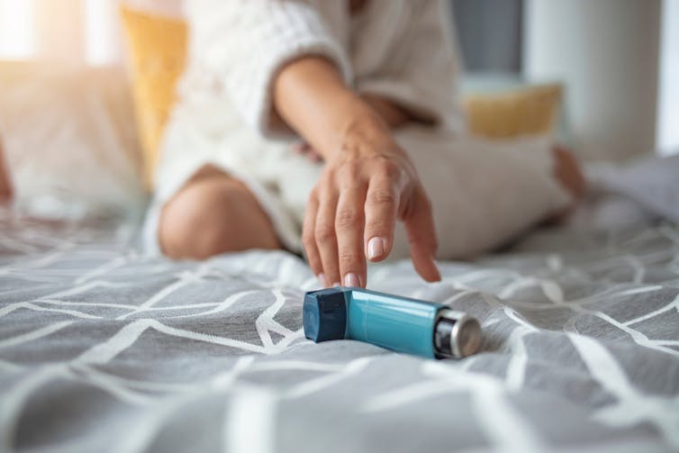 A woman with asthma reaching for her inhaler