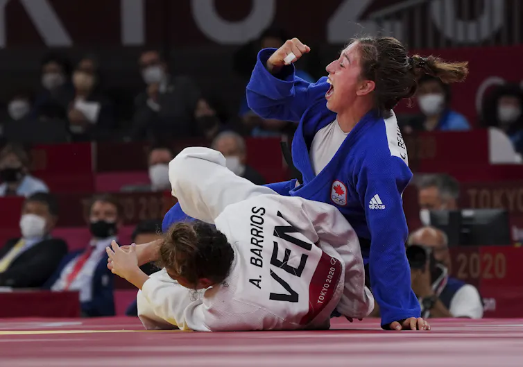 Catherine Beauchemin-Pinard lève son poing droit en signe de victoire alors que son adversaire est au tapis