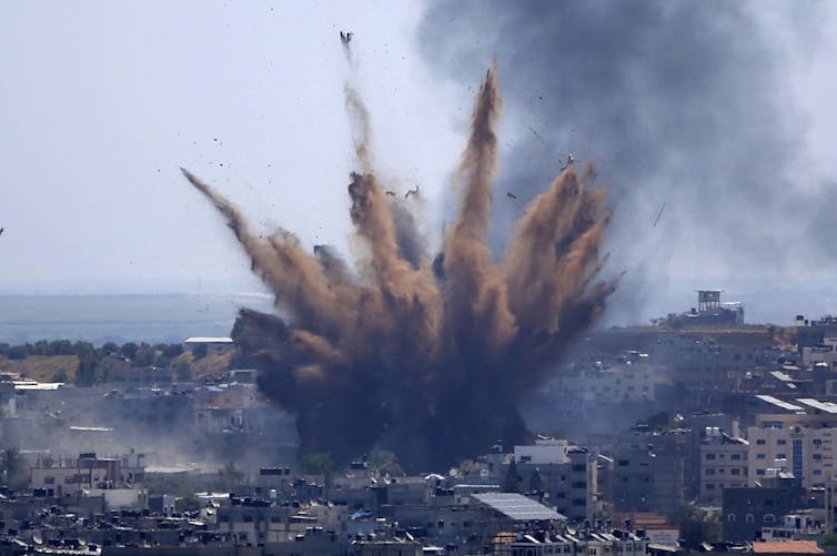 Uma explosão de fumaça e detritos sobe de um prédio que acabou de ser atingido por um ataque de míssil israelense em uma área densamente povoada da Cidade de Gaza