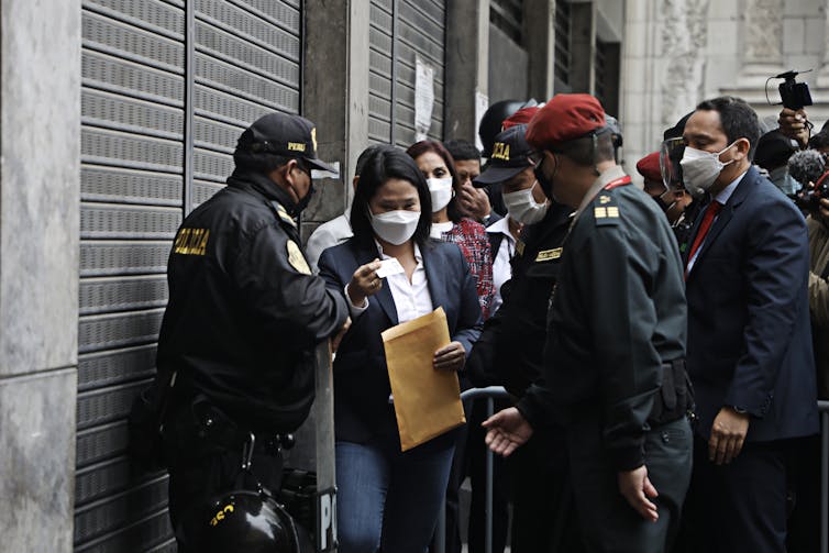 Fujimori passes through security holding a manila envelope in her hand