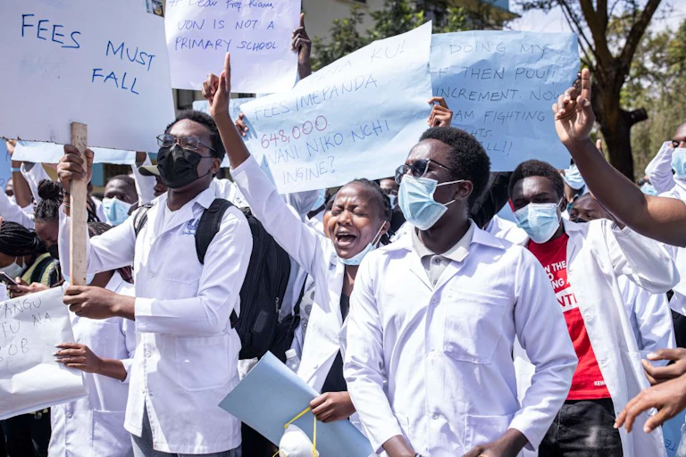 Students wave placards during a march over high tuition fees