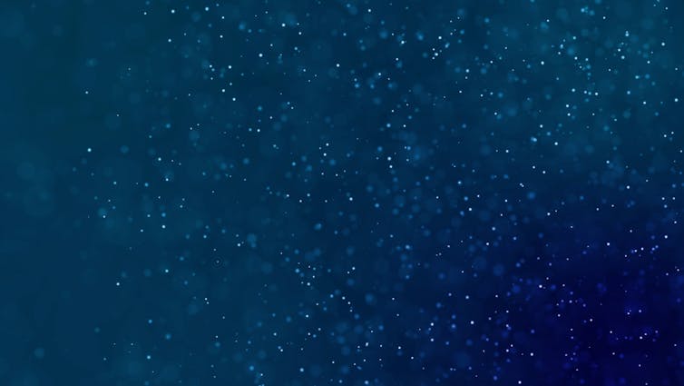 Blue ocean water background with dust particles flickering within