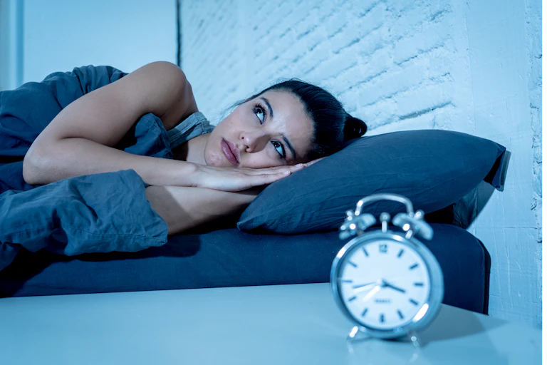 Una mujer en la cama con los ojos abiertos.