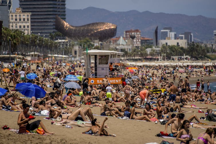 People sunbathe on the beach in Spain