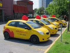 Delivery automobiles with the St-Hubert logo in a parking lot.
