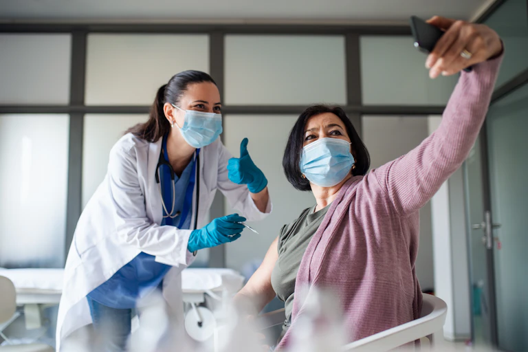 Doctor and patient take a selfie during vaccination