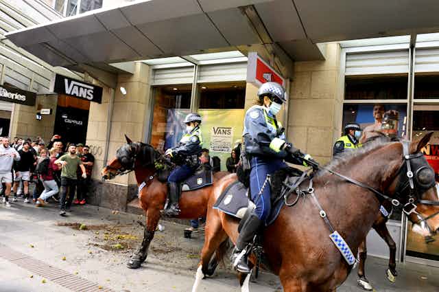 Protesters throw plastic bottles and pot plants at mounted police at Sydney Town Hall during the ‘World Wide Rally For Freedom’ anti-lockdown rally at Hyde Park in Sydney, Saturday, July 24, 2021