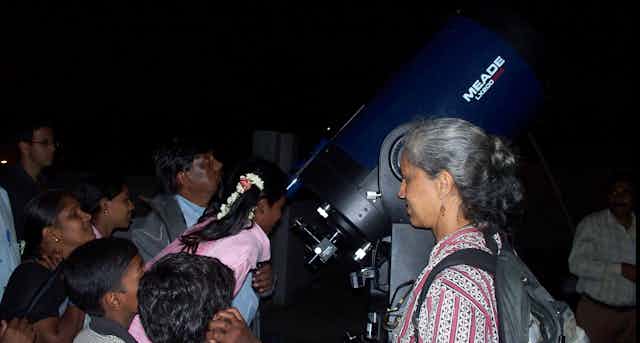 Prajval Shastri shows a telescope to children living in an Indian slum