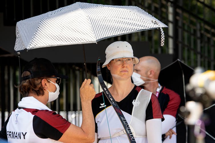 German archer Lisa Unruh is protected from the heat with a parasol