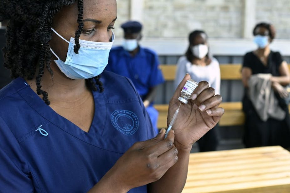 A health worker fills a syringe with a dose of the AstraZeneca/Oxford vaccine 