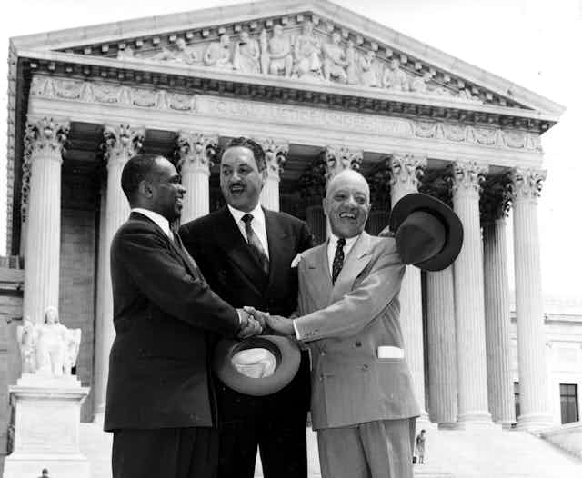 Thurgood Marshall, center, and two other men stand in a 1954 photo on the steps of the U.S. Supreme Court