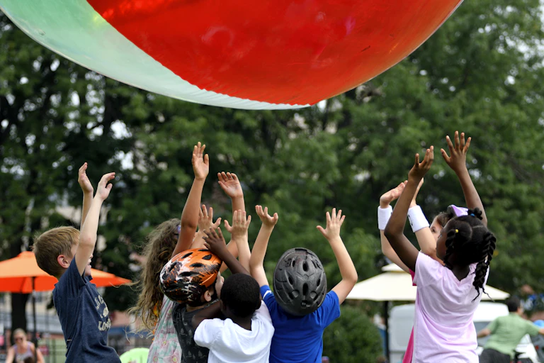 Kids play with giant inflatable beach ball