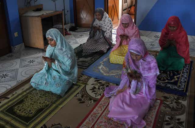 Family members offer a special prayer in their home during Eid-al-Fitr, which marks the end of Islamic holy fasting month of Ramadan.