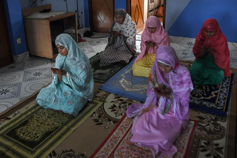 Family members offer a special prayer in their home during Eid-al-Fitr, which marks the end of Islamic holy fasting month of Ramadan.