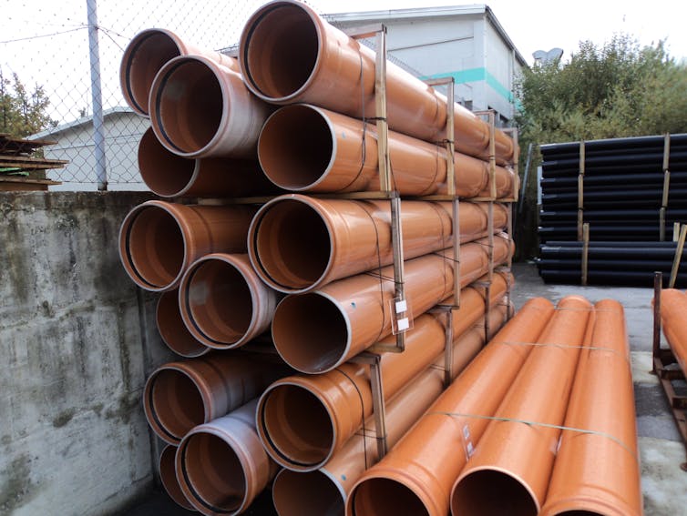 A stack of reddish plastic pipes.