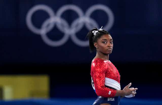 Waist-up shot of a woman in red, white, and blue leotard.