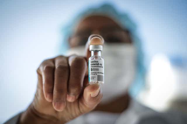 Health worker holding a vial of COVID-19 vaccine