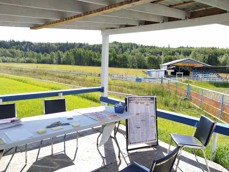 Tables are set up with greenery in the background. A sunny day, looks like a boardroom outside