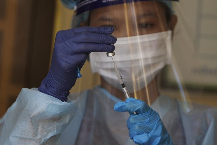 Health worker preparing a COVID-19 vaccine dose