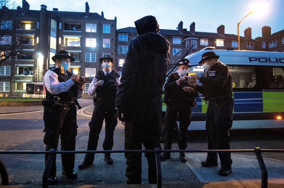 Police stop and search a man in Southwark, London.