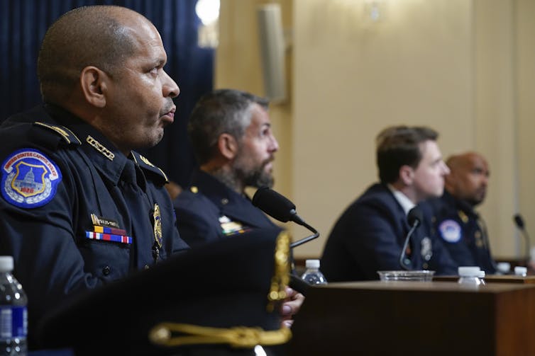 Four policemen sitting at a table in a Congressional hearing.