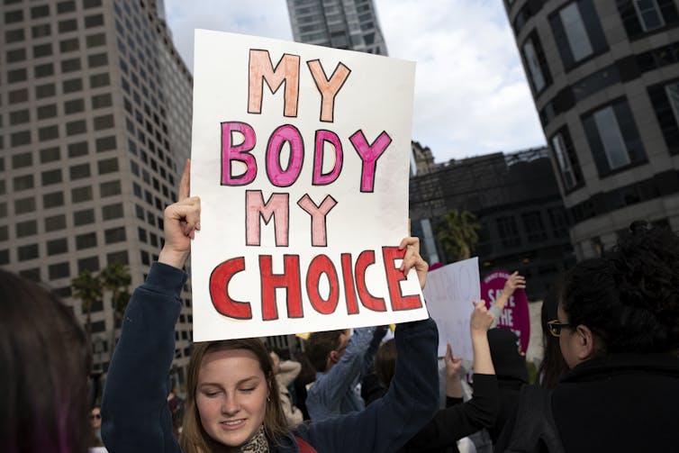 An activist seen holding a placard that says, 'My body My Choice.'