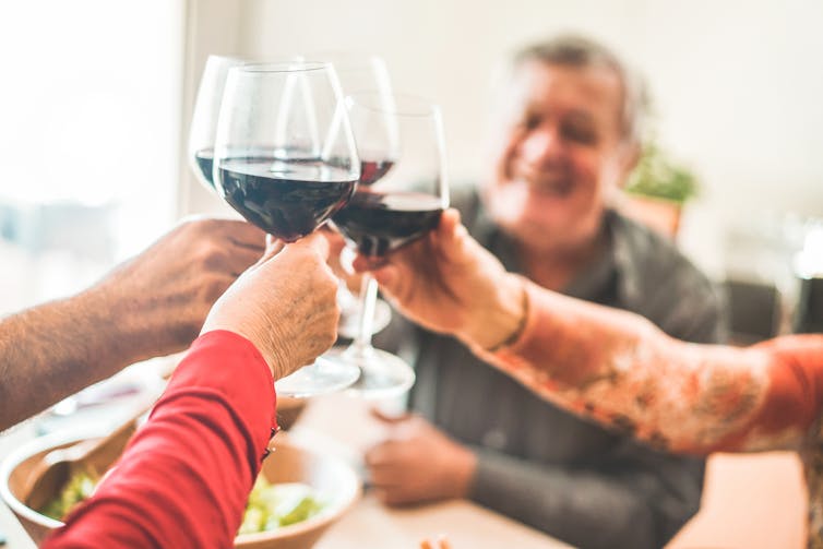 people clink wine glasses