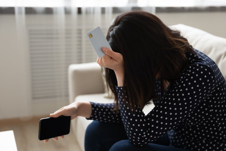 A woman contemplates credit card debt.