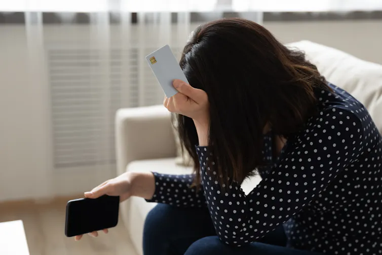 A woman contemplates credit card debt.