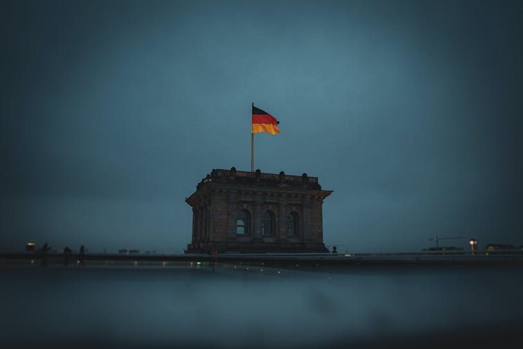 German flag on top of the Reinchstag at dusk