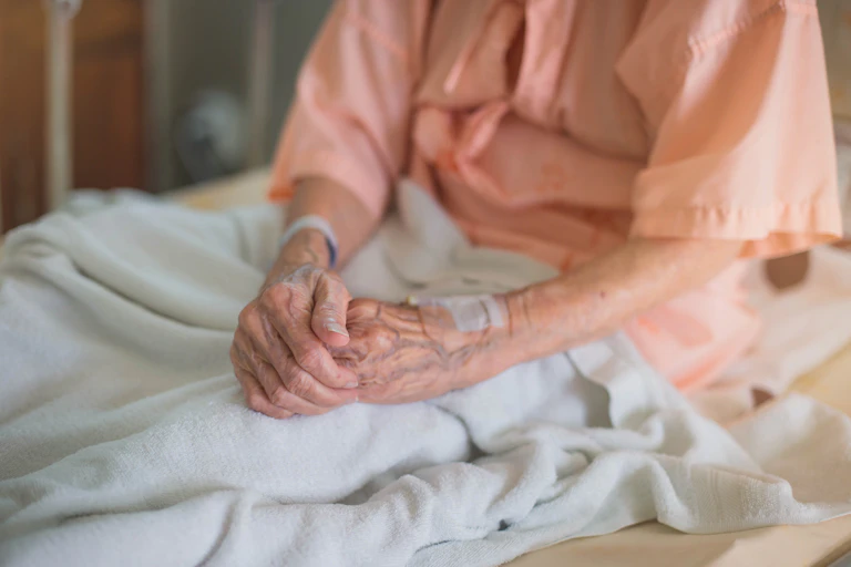 An elderly person sitting in a hospital bed.