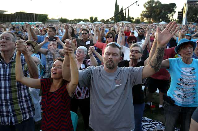 Evangelicals hold hands and pray during a tour by Rev. Franklin Graham in Turlock, California, in 2018.