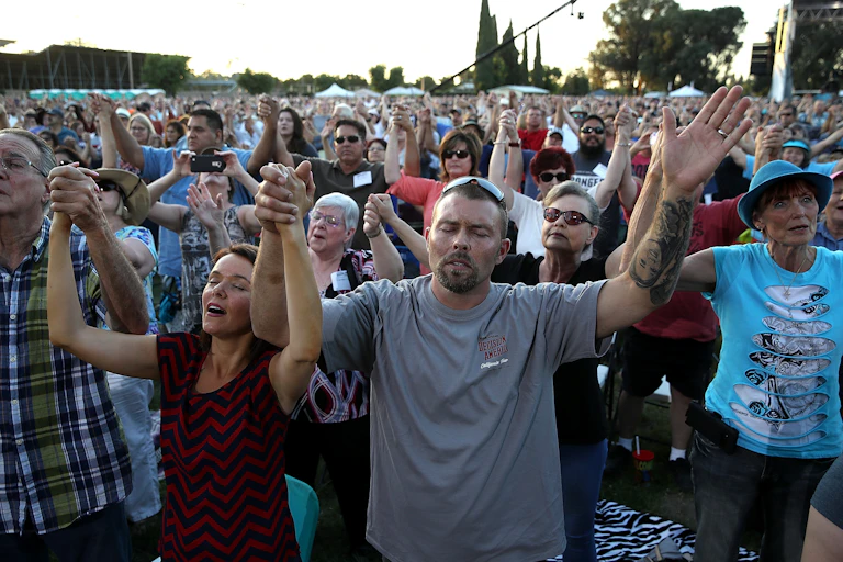 Evangelicals hold hands and pray during a tour by Rev. Franklin Graham in Turlock, California, in 2018.