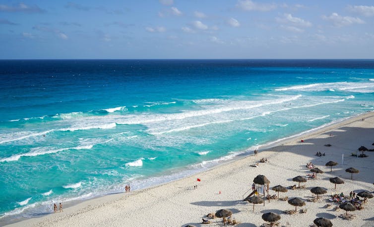 A beach and blue sea with umbrellas