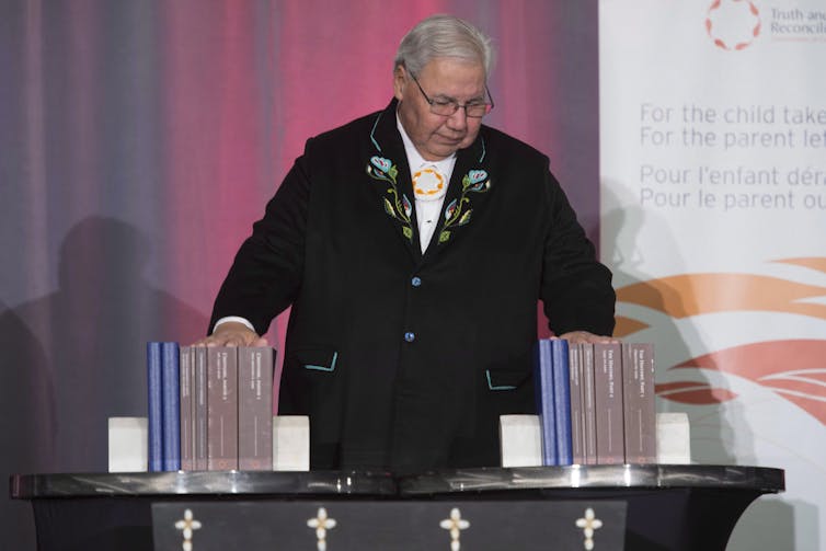 Murry Sinclair holds all the volumes of the TRC final report