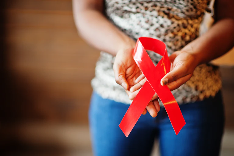 Black woman holding AIDS ribbon.