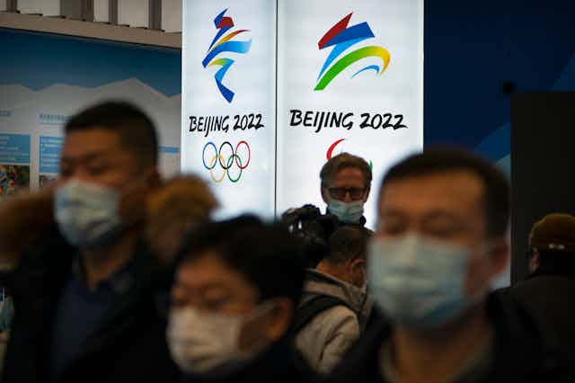 Crowd of people in front of a BEIJING 2022 banner