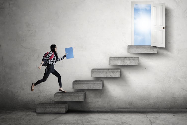 student running up stairs to a door opening to a sunny sky