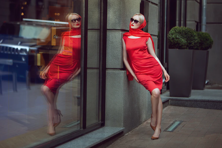 Image of a fashionable woman admires herself in the reflection of the shop window.