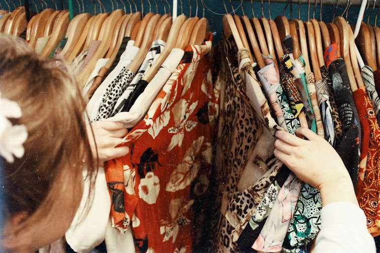 Woman looking at blouses on a clothing rack