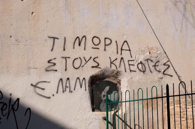 Graffiti on a wall in Cyprus, reads 'punishment for thieves ELAM'.
