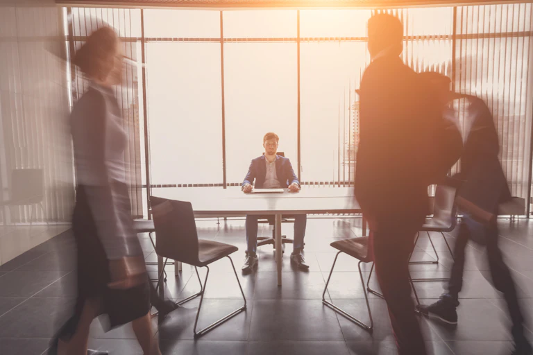 Employees walk into a meeting room