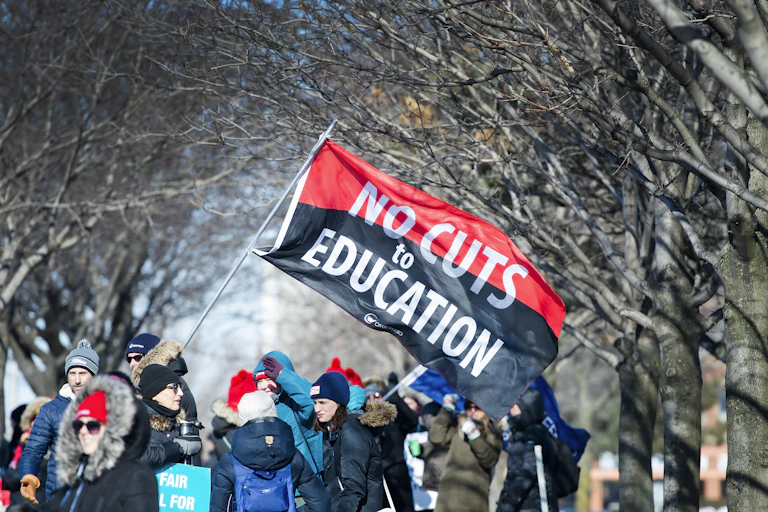 Teachers amass under trees during a one-day strike.
