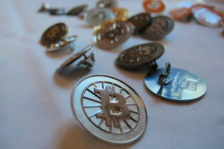 A bunch of bitcoin buttons are sitting on a table