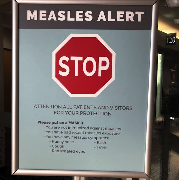 A stop sign reading 'measles alert'.