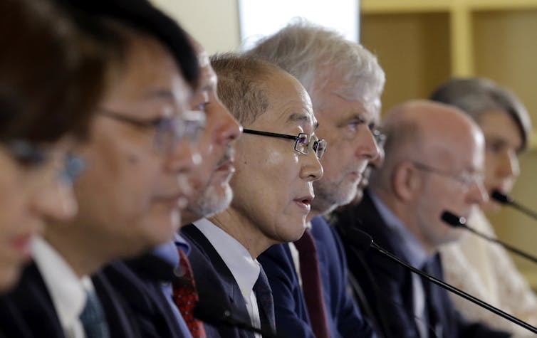 A row of male and female speakers at microphones