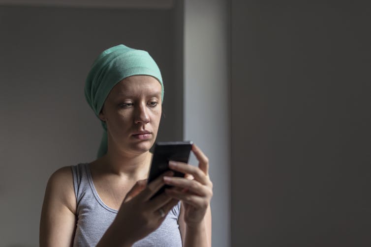 A woman wearing a tight cap speaks on her smartphone.